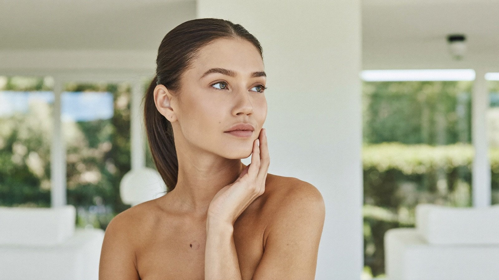 A woman with luminous, rested-looking skin in soft natural light